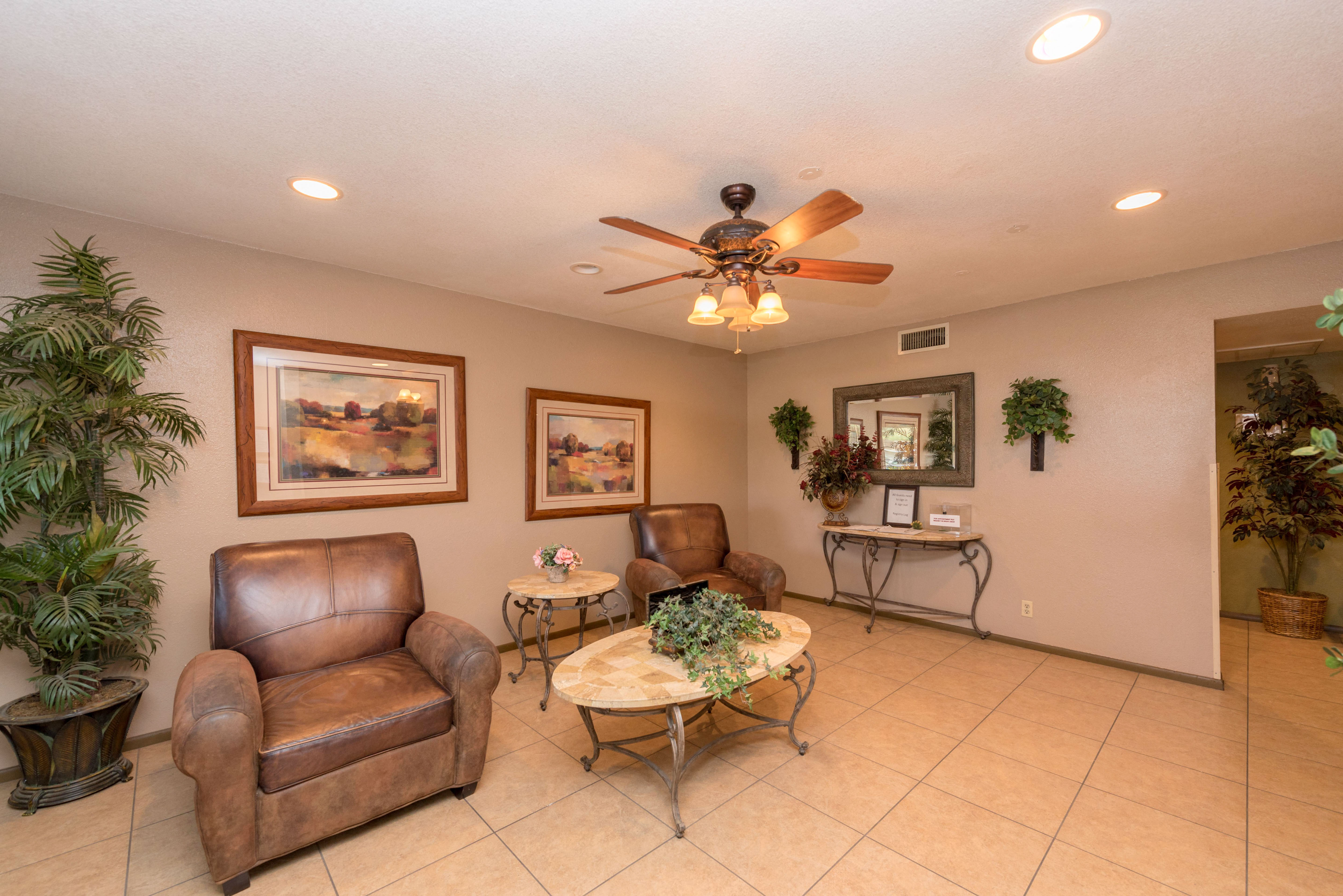 a living room with leather furniture and a ceiling fan