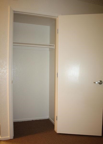 an empty room with a closet and a white door