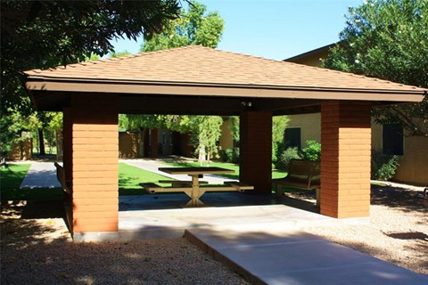a pavilion with a picnic table in a backyard
