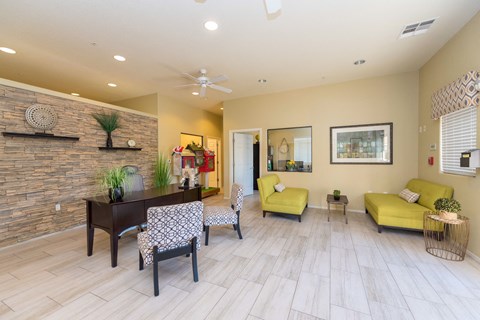 a living room with yellow furniture and a brick wall