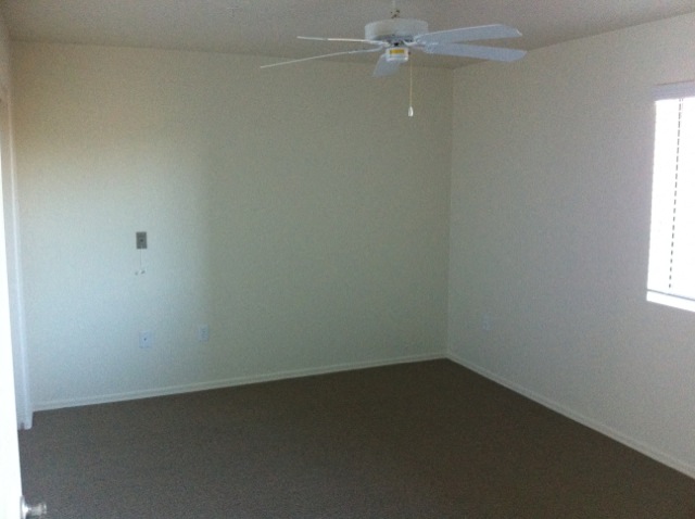 an empty room with a ceiling fan in it