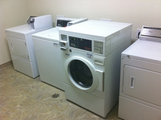 a group of washing machines and other appliances in a laundromat