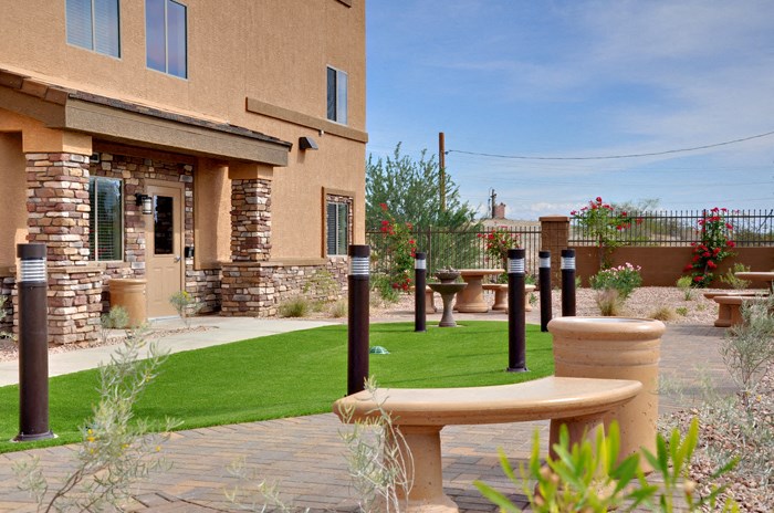 a patio with a table and a lawn in front of a house