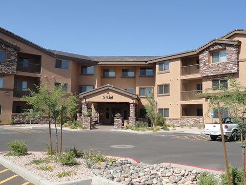 an outside view of a large hotel building with a parking lot and a truck