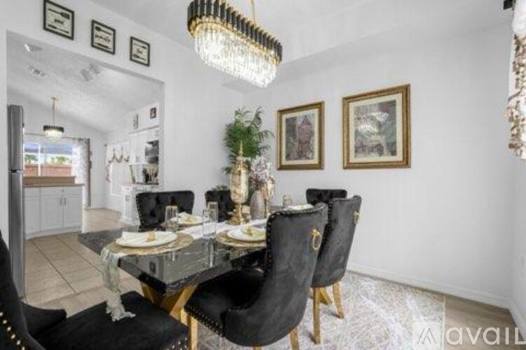 A dining room with a glass table and black chairs.