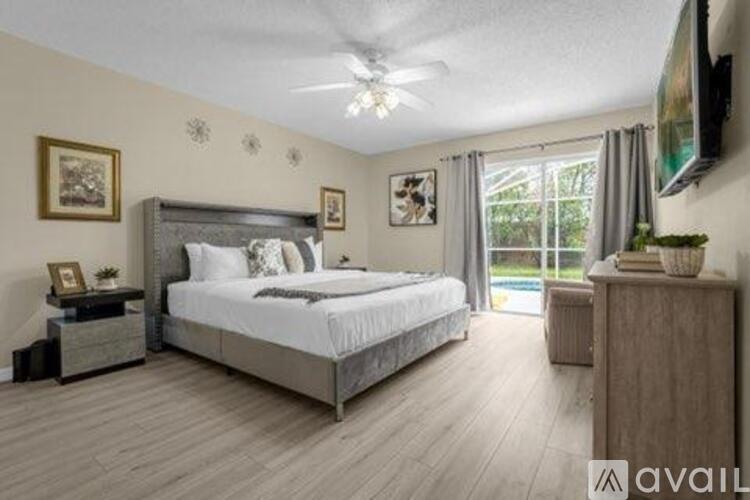 A bedroom with a large bed and a television mounted on the wall.
