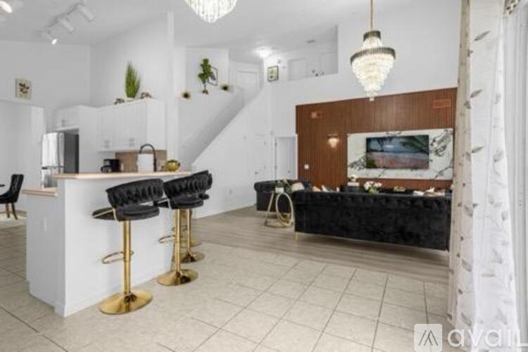A modern kitchen with a bar area and a staircase.