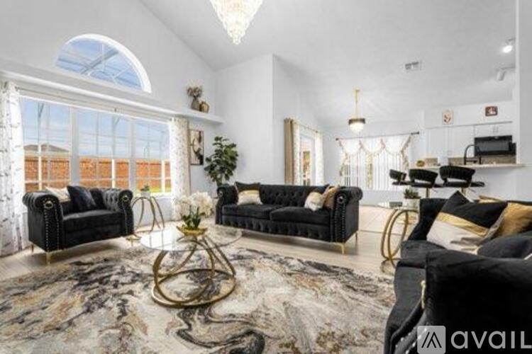 A living room with black sofas and a large marble table.