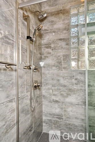 A shower area with a glass door and a glass wall.
