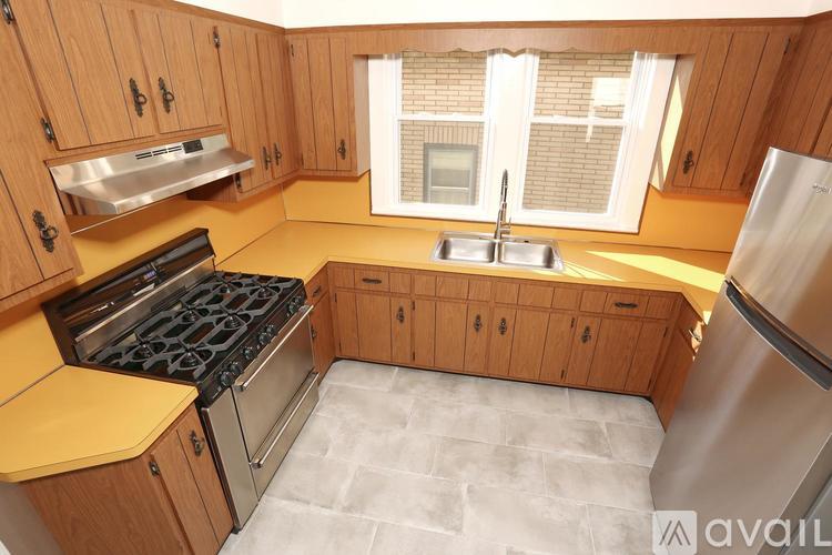 A kitchen with wooden cabinets and a stainless steel refrigerator.