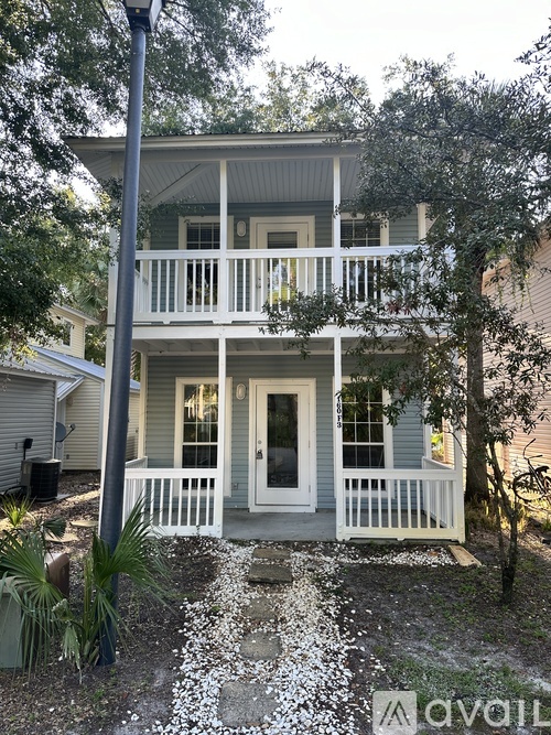 A house with a white front porch and a grey door.