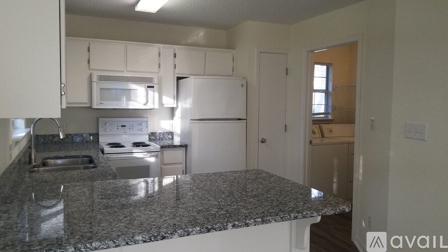A kitchen with granite countertops and white appliances.