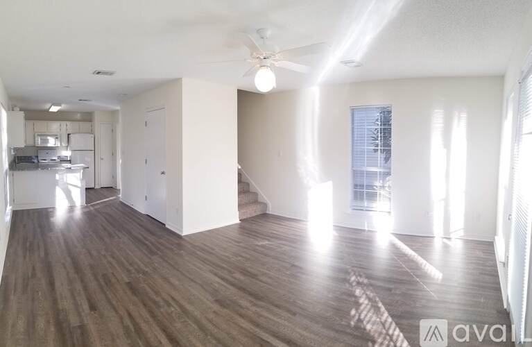 A spacious room with wooden flooring and a ceiling fan.
