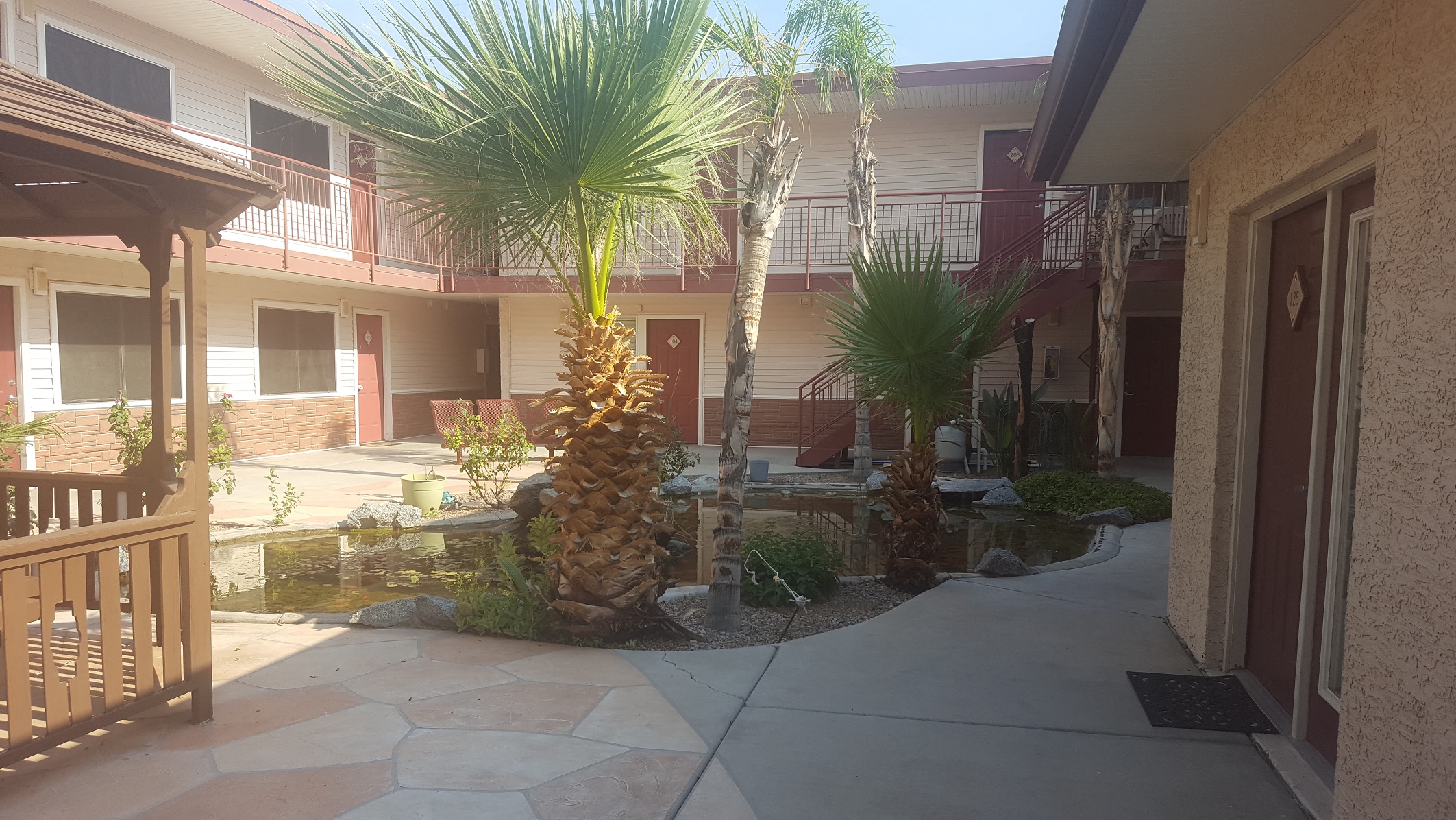 a courtyard with palm trees in front of a building