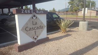 a street sign that reads la cascade i in front of a parking lot