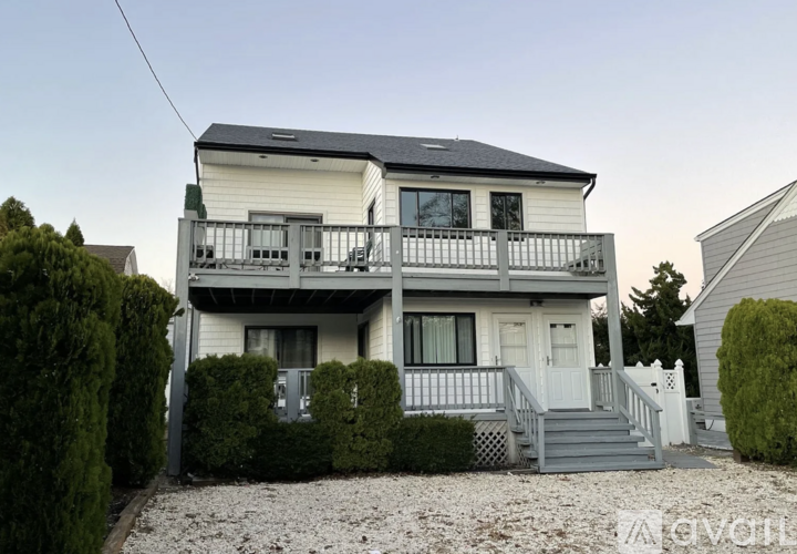 A two-story house with a balcony on the second floor.
