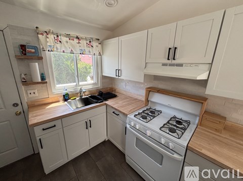 A kitchen with white cabinets and a wooden countertop.