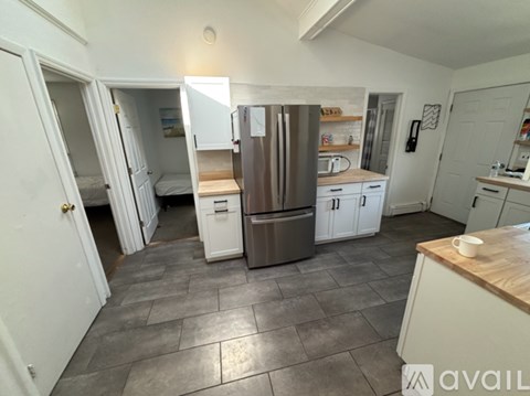 A kitchen with a refrigerator, microwave, and oven.