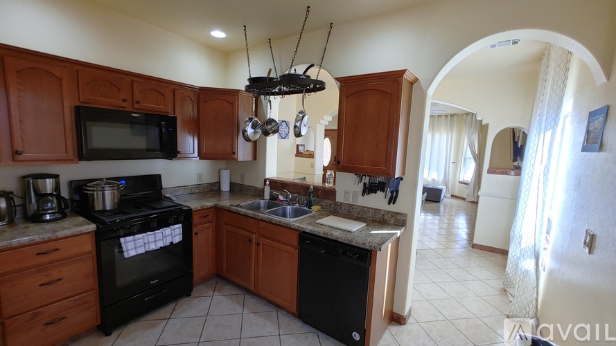 A kitchen with brown cabinets and black appliances.
