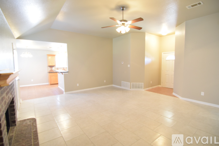 A spacious room with a ceiling fan and tiled floor.