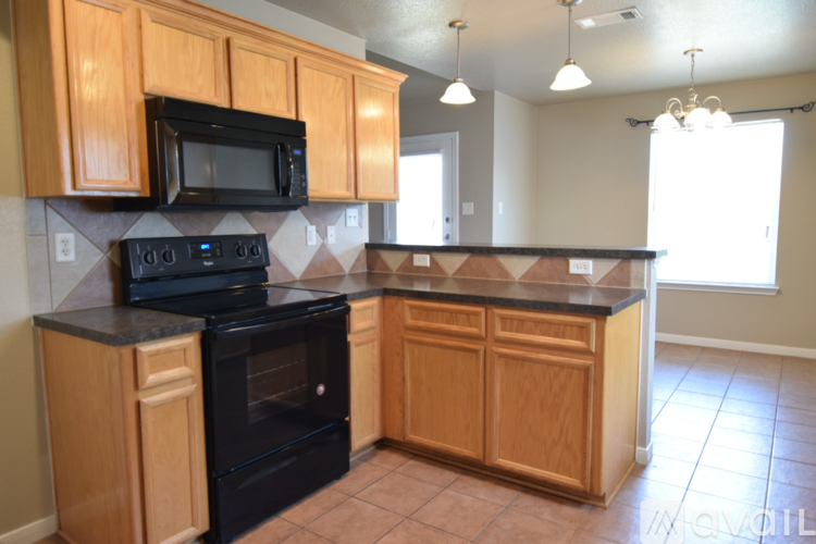 A kitchen with wooden cabinets and black appliances.