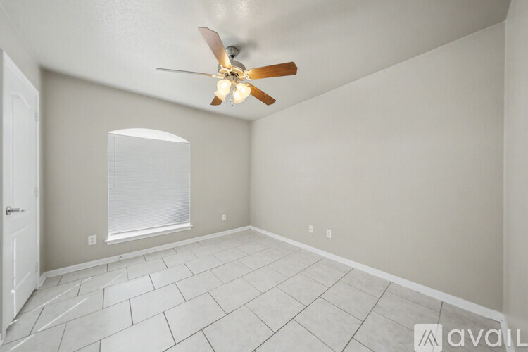 A spacious living room with a fireplace and a ceiling fan.