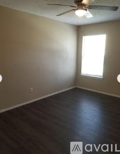 A room with a ceiling fan and a window.