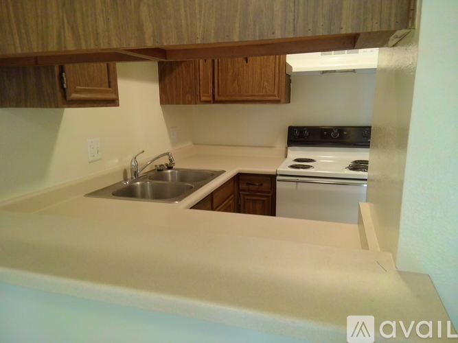 A kitchen with wooden cabinets and a stove top oven.