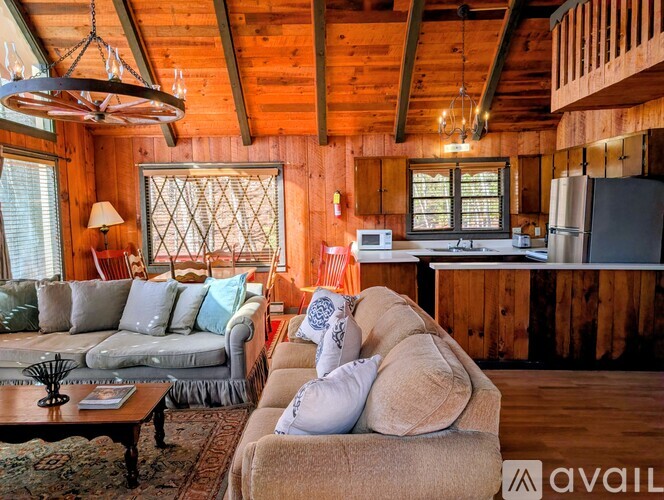 A living room with a couch, a coffee table, and a window.