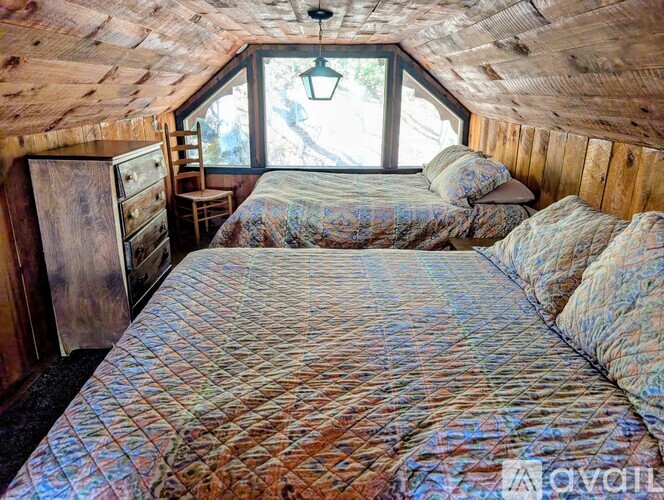 A bedroom with two beds and a wooden dresser.