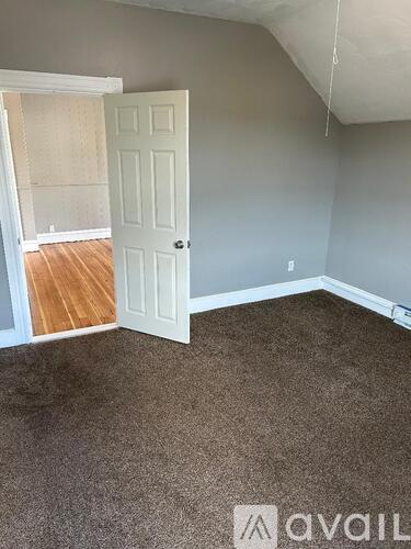 A room with a carpeted floor and a door.