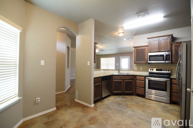 A kitchen with brown cabinets and a stainless steel refrigerator.