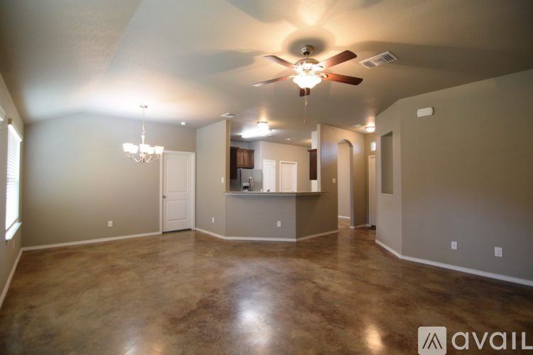 A spacious room with a ceiling fan and a chandelier.