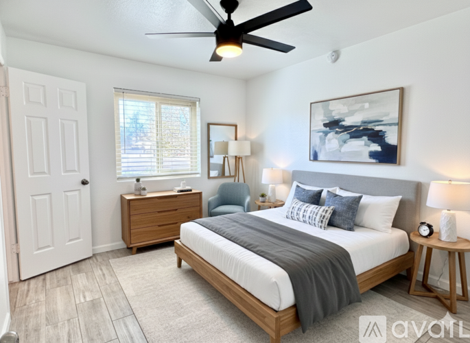 A bedroom with a bed, nightstand, and a ceiling fan.