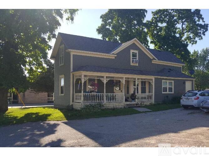 A house with a grey front and a white porch.