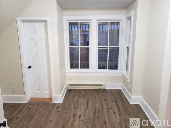 A room with a white door and a window with white frames.