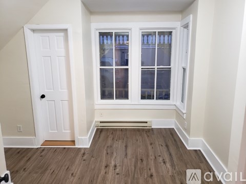 A room with a white door and a window with white frames.