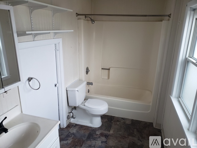 A white bathroom with a toilet, sink, and bathtub.
