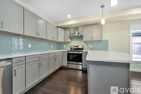 A kitchen with white cabinets and a stainless steel dishwasher.