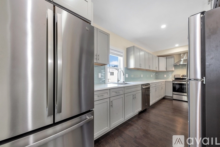 A modern kitchen with stainless steel appliances and wooden floors.
