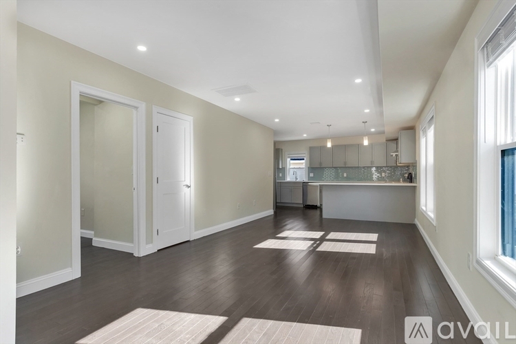 A spacious room with wooden floors and white walls.