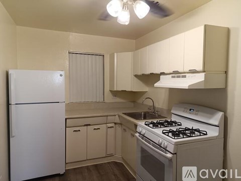 A small kitchen with a white fridge and a white stove.