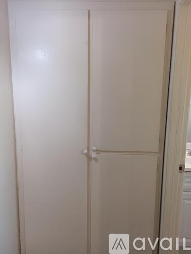 A white door with a handle is closed.