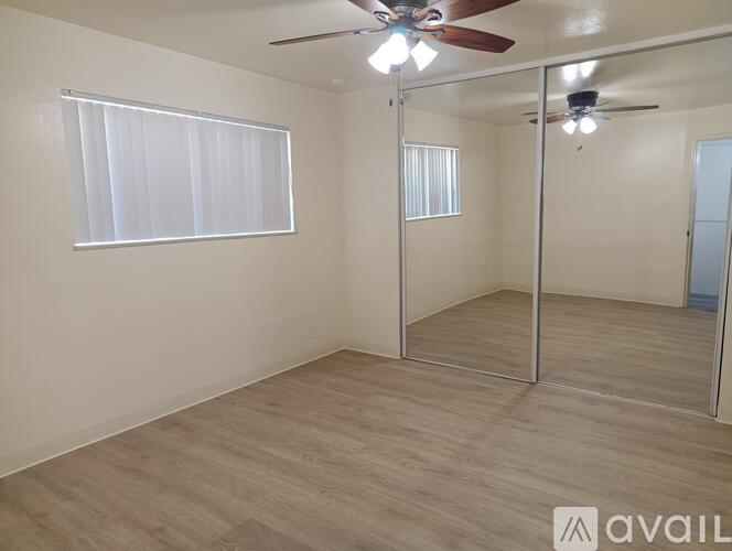 A room with a ceiling fan and a sliding glass door.