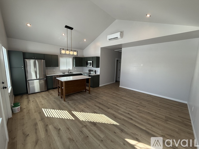 A kitchen with wooden floors and a refrigerator.