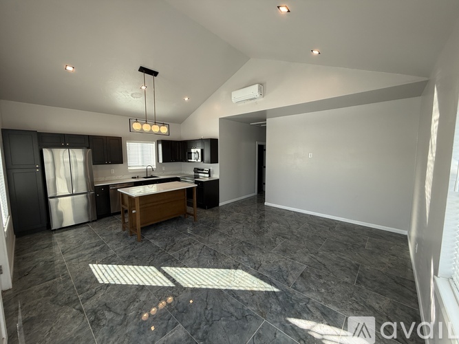 A modern kitchen with a refrigerator, microwave, and oven.