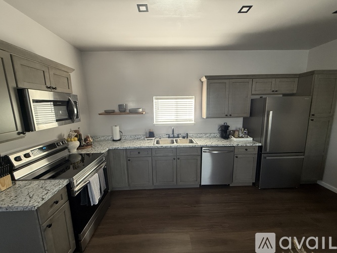 A modern kitchen with stainless steel appliances and wooden floors.