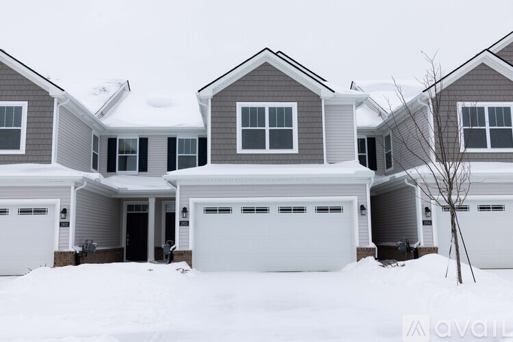 A house with a white garage door in the snow.