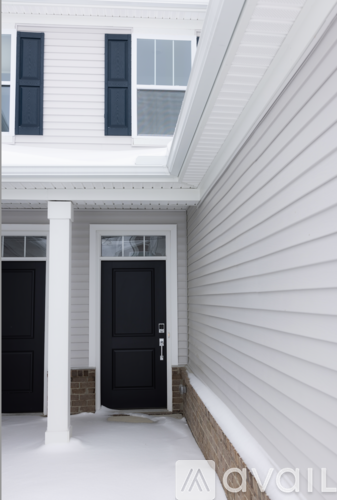 A white house with two black doors and a window.