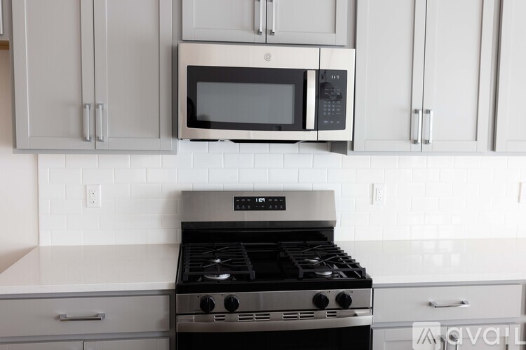 A modern kitchen with a black stove top oven and a microwave above it.